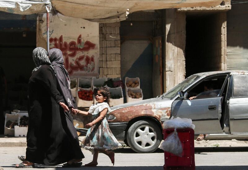 A Syrian girl holds a woman's hand as she walks down a street in the central Syrian rebel-held town of Talbiseh, north of Homs on August 3, 2017. 
A ceasefire between government forces and rebels went into effect in part of central Syria on August 3, 2017 after Russia struck a deal with the opposition on a safe zone in the northern parts of Homs province. 
The truce is the third to be established in Syria, which has been ravaged by six years of civil war that have left more than 300,000 people dead. / AFP PHOTO / MAHMOUD TAHA