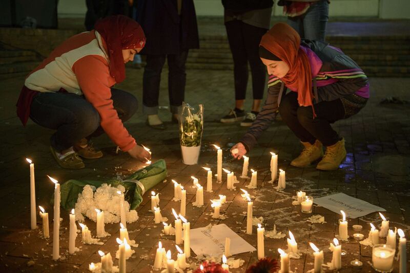 People stand by as a makeshift memorial is made after vigil at the University of North Carolina following the murders of three Muslim students on February 11, 2015. Brendan Smialowski / AFP