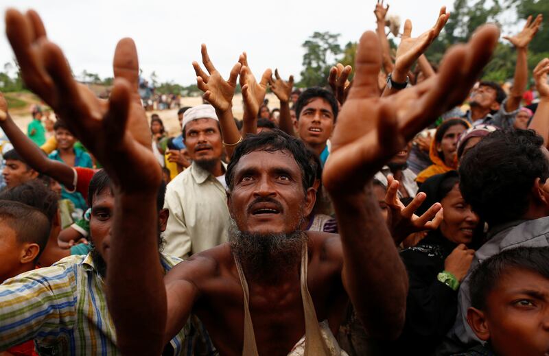 Rohingya refugees stretch their hands to receive food distributed by local organizations in Kutupalong, Bangladesh, September 9, 2017. REUTERS/Danish Siddiqui