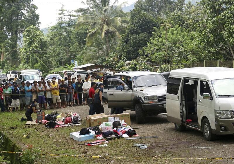 Residents watch as police inspect the contents of two vehicles in which mayor Samsudin Dimaukom of Datu Saudi Ampatuan township and nine others were travelling before they were killed in a dawn gunbattle with anti-narcotics officers at Makilala township, North Cotabato province, on October 28, 2016. AP Photo