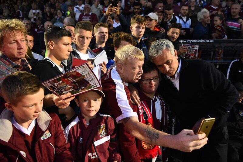 Manchester United manager Jose Mourinho poses for selfie photographs with Northampton Town fans. Laurence Griffiths / Getty Images