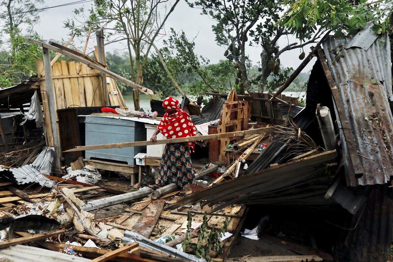 A woman clears her house that was demolished by the cyclone Amphan in Satkhira, Bangladesh. REUTERS
