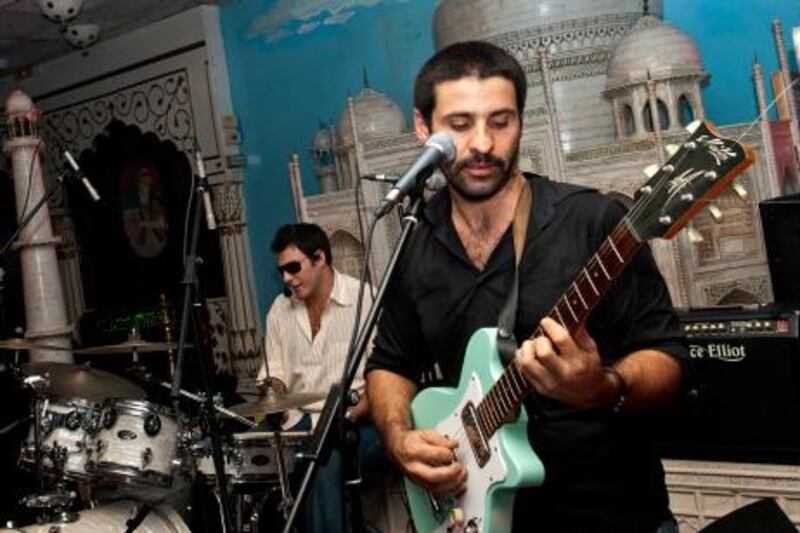 (FILES)--A November 2 2007, file photo shows Lebanese singer Zeid Hamdan playing his guitar at the Maharaja restaurant in Beirut. Hamdan, 35-years-old, was detained on July 27, 2011, for slandering Lebanon's head of state in a song posted on YouTube in which he urges President Michel Sleiman to "go home," his attorney told AFP. AFP PHOTO/GHADI SMAT