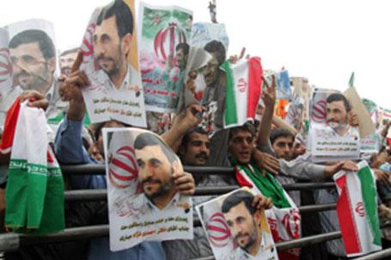 Thousands of supporters of Iran's hardline President Mahmoud Ahmadinejad (portraits) wave national flags during a massive rally to celebrate his victory in the presidential elections in Tehran's Valiasr square.