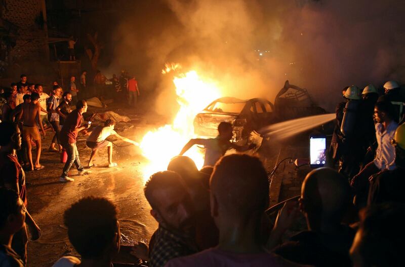 People extinguish a fire from a blast outside the National Cancer Institute, Cairo, Egypt. Reuters