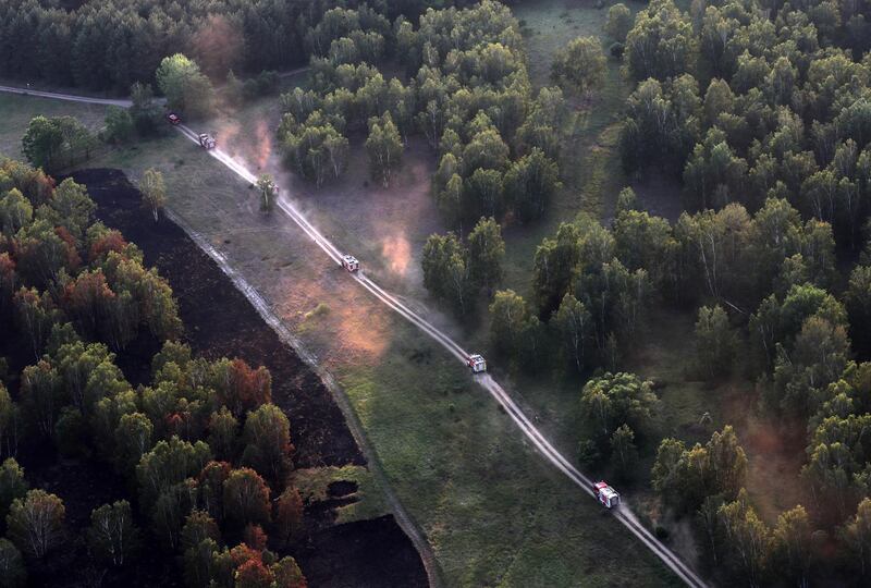 Firefighting trucks drive to a point of fire at a forest near Juterbog, Brandenburg, Germany.  EPA