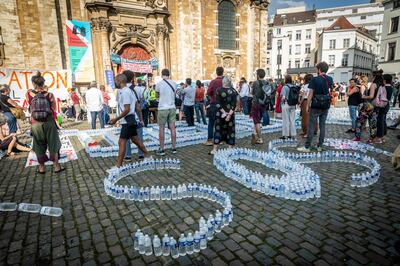The word SOS is spelled out with water bottles during a demonstration at the Beguinage church in Brussels. AFP