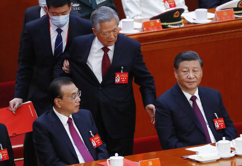 China's former President Hu Jintao, centre, is led out behind President Xi Jinping, right, and Premier Li Keqiang at the Communist Party's National Congress on October 22. EPA