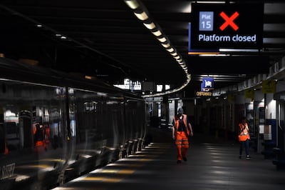 Workers walk along a closed platform during a strike by members of the National Union of Rail, Maritime and Transport Workers (RMT) at Euston Station in London. Bloomberg