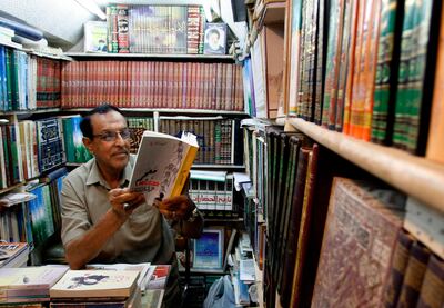 An Iraqi man reads a book at a shop in the Howeish book market in the holy city of Najaf, 150 kilometres (95 miles) south of Baghdad, on August 16, 2018.
 In the covered alleyways of old Najaf in Iraq, poetry and philosophy books compete with economic treatises, the Koran and other theological tomes for students' attention. / AFP / Haidar HAMDANI
