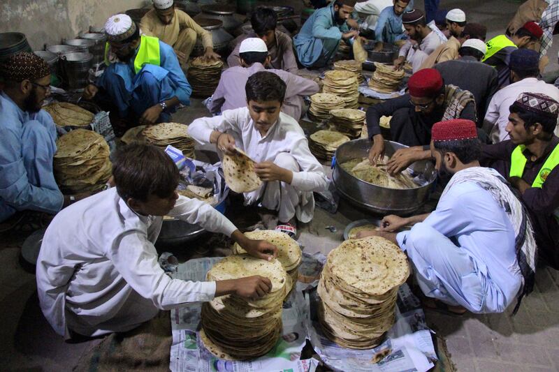 Al Mahmood Social Welfare Association workers prepare food aid in Larkana, Pakistan. EPA