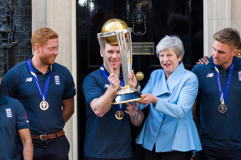 British prime minister Theresa May and England captain Eoin Morgan pose with the World Cup trophy. EPA