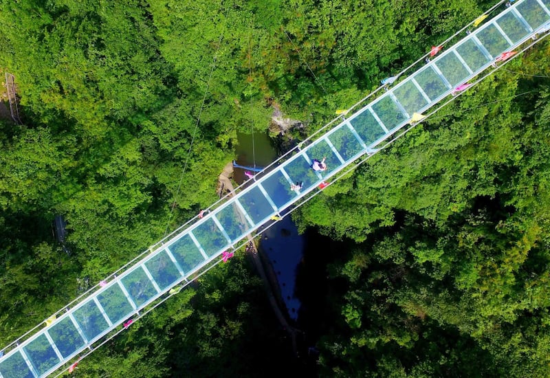 An aerial view of people walking on a glass-bottomed skywalk at Shimenxian Lake in Rongan in south China's Guangxi region. AFP