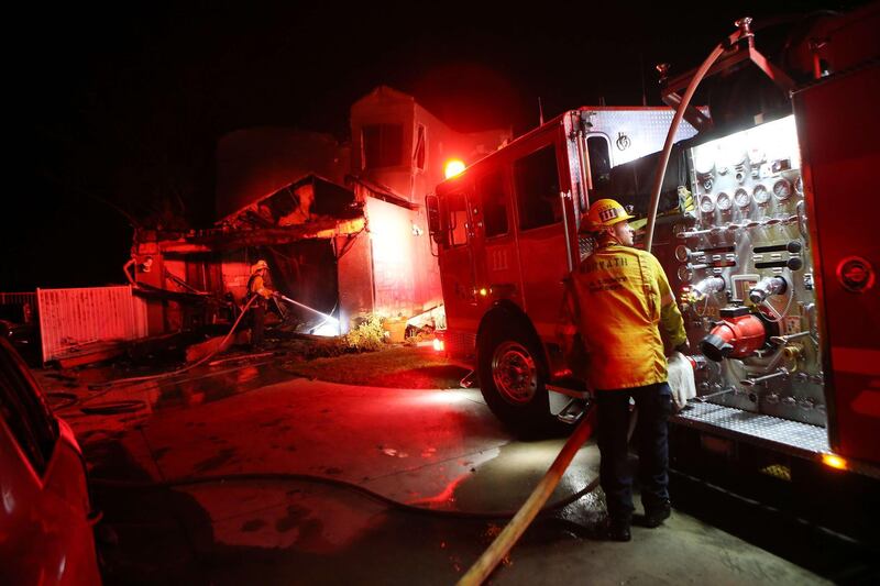 Firefighters work at a home destroyed by the Tick Fire in Canyon Country. AFP