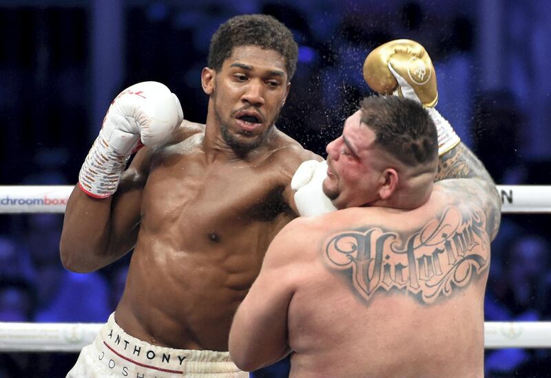 British boxer Anthony Joshua (white trunks) competes with Mexican-American boxer Andy Ruiz Jr (golden trunks) during the heavyweight boxing match between Andy Ruiz Jr. and Anthony Joshua for the IBF, WBA, WBO and IBO titles in Diriya, near the Saudi capital on December 7, 2019. - Joshua reclaimed his world heavyweight crown from Andy Ruiz, outclassing the Mexican-American to score a unanimous points victory. (Photo by AFP)