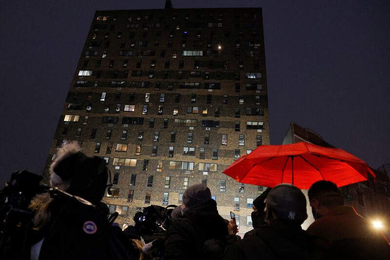 Onlookers gaze up at the building where the fire broke out. Reuters