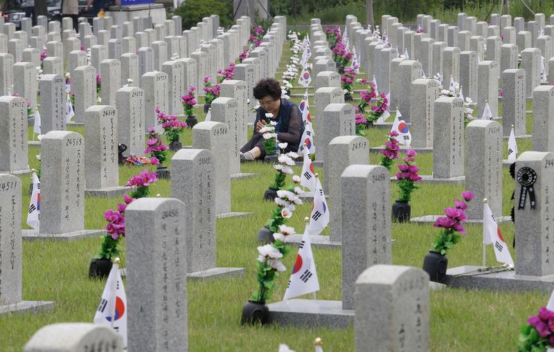 South Korean Lee Jin-yeo prays in front of the gravestone of Lee Kwan-joon, a male cousin of her father, who died during the Korean War, on Memorial Day at the National Cemetery in Seoul, South Korea. AP