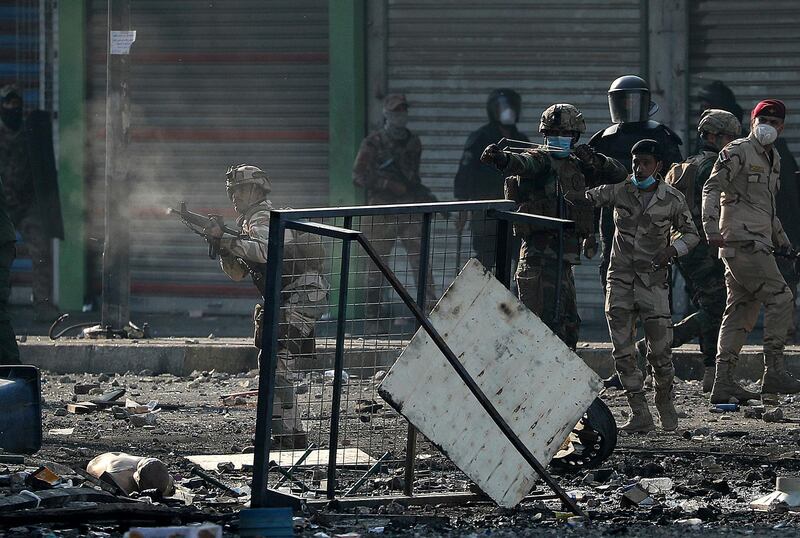 Iraqi security forces fire tear gas, a slingshot and smoke bombs during clashes between Iraqi security forces and anti-government protesters, in Baghdad. AP Photo