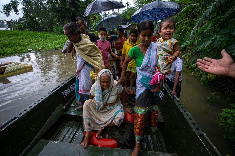 Indian army personnel rescue flood-affected villagers on a boat in Jalimura village, west of Gauhati, India, on June 18. More than a dozen people have died as massive floods ravaged northeastern India and Bangladesh, leaving millions of homes underwater and severing transport links. AP