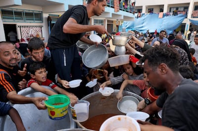 Palestinian children receive food at a UN-run school in Rafah. AFP