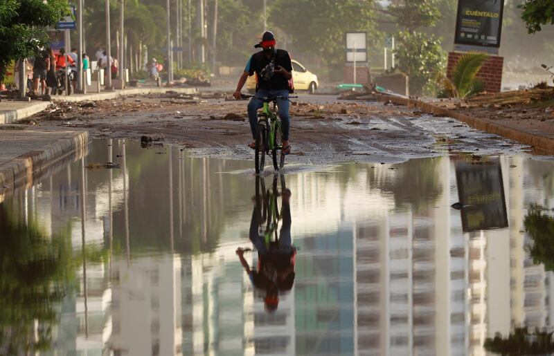 A man rides a bike through an avenue flooded by the passage of hurricane Iota, in Cartagena, Colombia. EPA