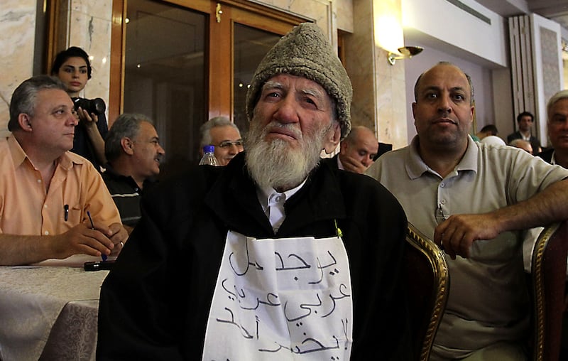 Muslim cleric Jawdat Said holds a sign which says: ‘There is an Arab solution in which nobody loses’. He was attending a public meeting of opposition figures, in the Syrian capital, Damascus, on June 27, 2011, to discuss the uprisings that began in March that year. AFP