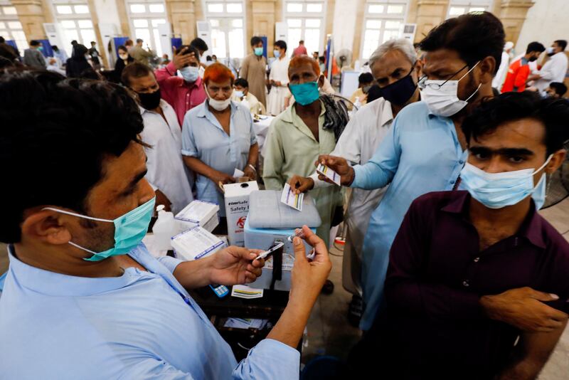 Residents receive Covid-19 vaccine shots at a centre in Karachi. Reuters