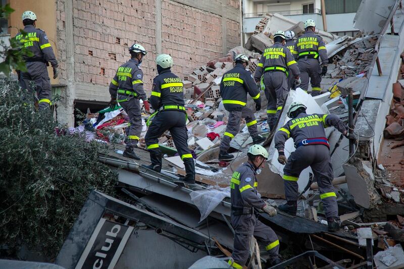 Rescuers from Romania work at a collapsed building. AP Photo