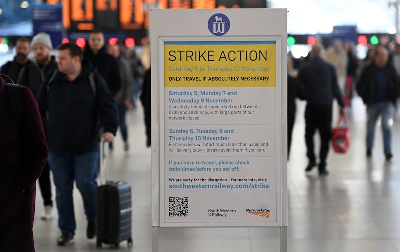 Commuters at Waterloo Station in London walk past a sign warning of strike action, which never happened. EPA