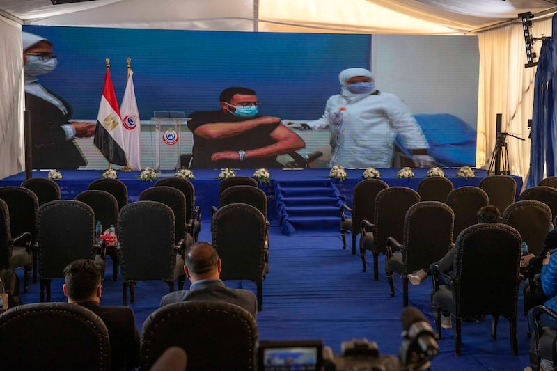 Dr. Abdel Menoim Selim, the first Egyptian to receive the  Sinopharm China-made COVID-19 vaccine, is seen on a live screen ahead of a press conference, at the Abu Khalifa Hospital in Ismailia, 120 kilometers (75 miles) east of Cairo, Egypt, Sunday, Jan. 24, 2021. (AP Photo/Nariman El-Mofty)