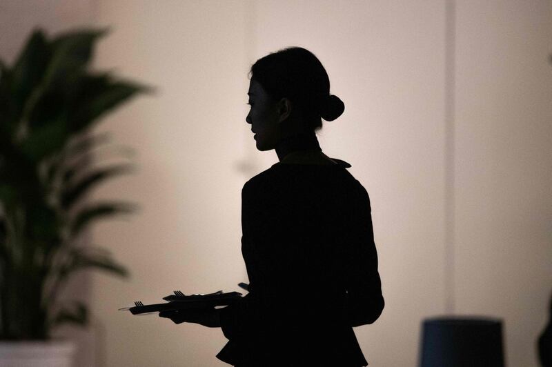 A hostess welcomes journalists and guests at the Huawei database and storage product launch during a press conference at the Huawei Beijing Executive Briefing Centre in  Beijing.  AFP