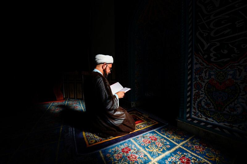 Shiite cleric Ali Al Atabi reads from the Quran in the vicinity of Imam Ali shrine in Iraq's central city of Najaf.  AFP