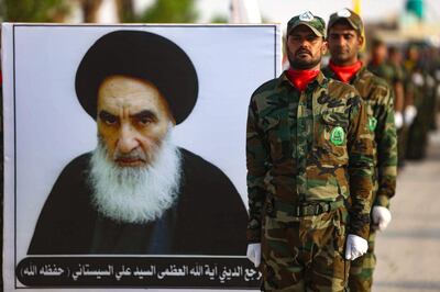 (FILES) In this file photo taken on August 30, 2019, members of the "Liwa al-Tafuf" 13th Brigade of Iraq's Shiite Muslim Hashed al-Shaabi (Popular Mobilisation units) carry a placard showing Ayatollah Ali Husaini al-Sistani during a graduation ceremony at a training centre in the central Iraqi city of Karbala.
 Around the corner from Iraq's holiest shrines, a years-long struggle over resources and reputations is coming to a head, threatening a dangerous schism within a powerful state-sponsored security force. The growing fissure pits the vast Iran-aligned wing of the Hashed al-Shaabi network against four factions linked to the shrines of Iraq's twin holy cities, Karbala and Najaf.
 / AFP / Mohammed SAWAF
