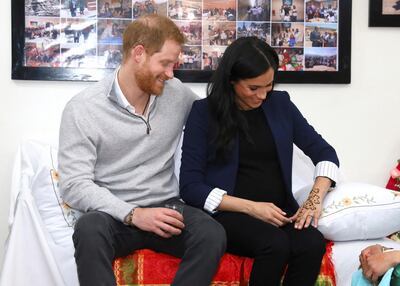 Britain's Prince Harry and Meghan, Duchess of Sussex look at her henna tattoo during a ceremony as they visit the "Education For All" boarding house in Asni Town in Morocco, Sunday, Feb. 24, 2019. The Duke and Duchess of Sussex are on a three day visit to the country. (Tim P. Whitby/Pool via AP)