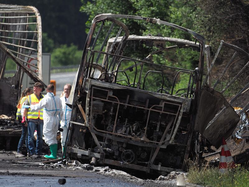 Forensic experts work on the wreckage of a bus after it crashed on the A9 highway near Muenchberg, southern Germany, on July 3, 2017. Up to 18 people were feared dead after a tour bus burst into flames following a collision with a trailer truck. Nicolas Armer / AFP