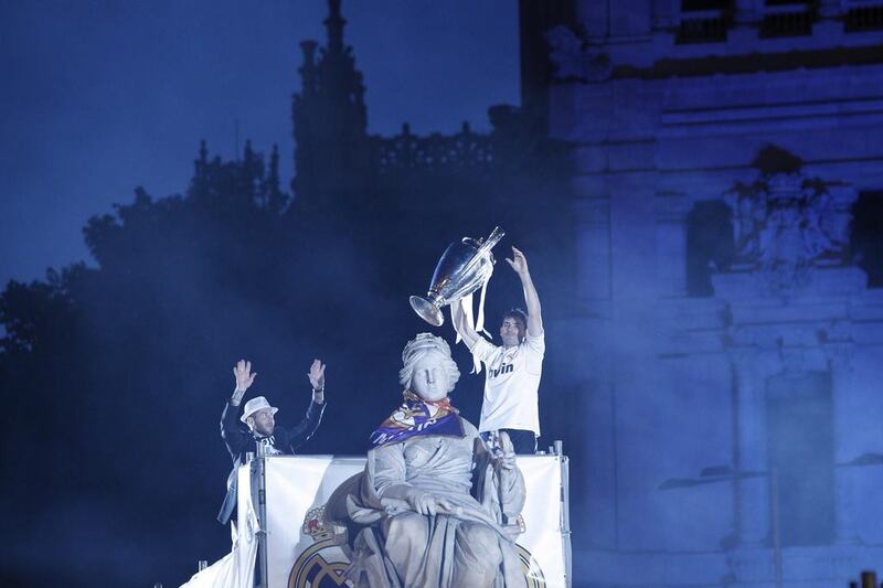 Real Madrid players Iker Casillas, right, and Sergio Ramos, left, celebrate with the Champions League trophy on top of the Cibeles fountain in Madrid on Saturday night. Zipi / EPA / May 24, 2014