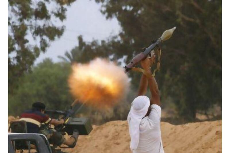 An anti-Qaddafi fighter fires an RPG-7 during fighting close to the centre of Sirte yesterday. Anis Mili / Reuters