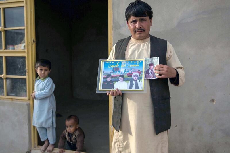 Khadija's husband holds a photo of his brothers in Helmand province - all of them killed in the conflict. Photo by Stefanie Glinski