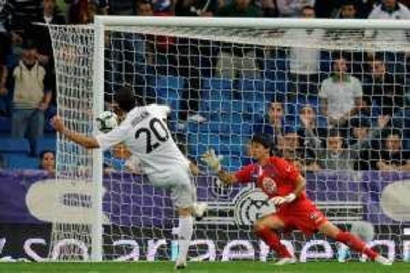 Real Madrid's Argentinian forward Gonzalo Higuain (L) scores against Getafe during a Spanish league football match at the Santiago Bernabeu stadium in Madrid, on October 31, 2009.  AFP PHOTO / Dani Pozo *** Local Caption ***  146397-01-08.jpg