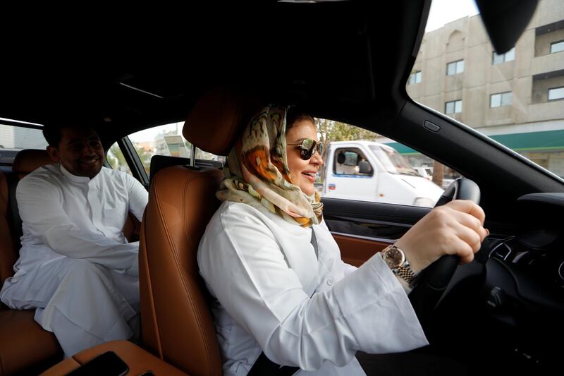 Samira al-Ghamdi, a practicing psychologist, drives to work with her son Abdulmalik, 26, sitting behind, in Jeddah, Saudi Arabia. Zohra Bensemra / Reuters