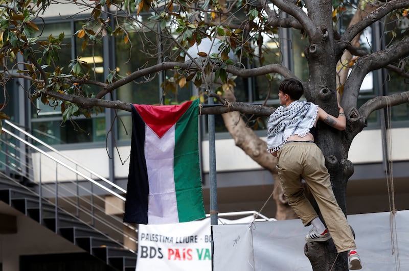 A student hangs a Palestinian flag at the encampment that has been set up on the campus of the University of Valencia, Spain. Reuters