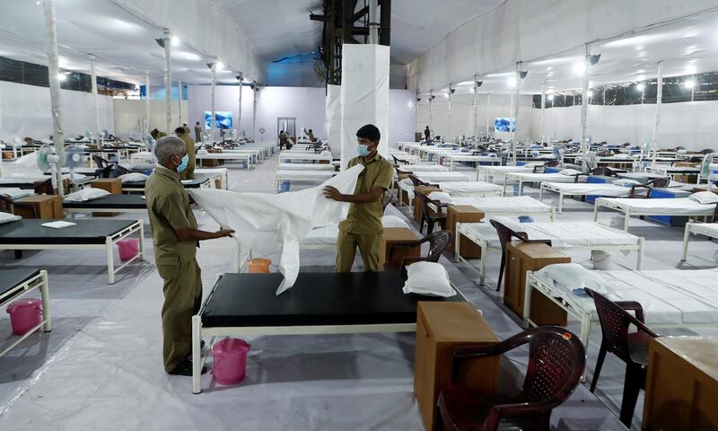 Workers prepare a bed at a recently constructed quarantine facility for patients diagnosed with the Covid-19 in Mumbai. Reuters