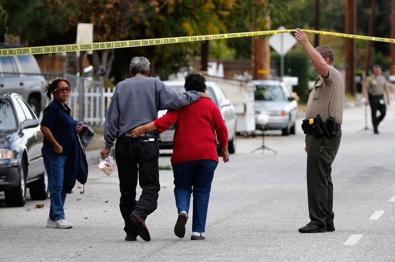 A police officer lets residents into San Bernadino Avenue, the scene of a mass shooting in California (Sean M. Haffey/Getty Images/AFP)