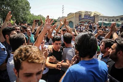 FILE - In this June 25, 2018 file photo, a group of protesters chant slogans at the main gate of the Old Grand Bazaar, in Tehran, Iran. On Saturday, Sept. 5, 2020, Iran broadcast the televised confession of a wrestler facing the death penalty after a tweet from President Donald Trump criticizing the case, a segment that resembled hundreds of other suspected coerced confessions aired over the last decade in the Islamic Republic. The case of 27-year-old Navid Afkari has drawn the attention of a social media campaign that portrays him and his brothers as victims targeted over participating in protests against Iran's Shiite theocracy in 2018. (Iranian Labor News Agency via AP, File)