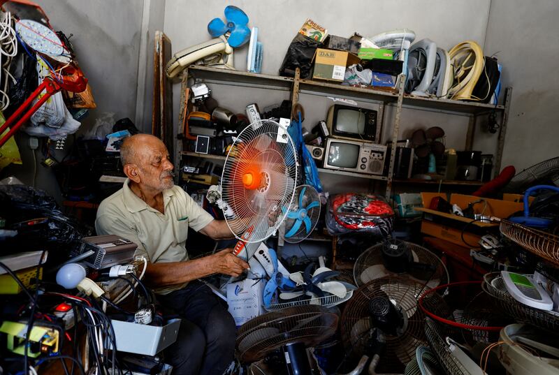 A Palestinian, Mustafa Abdou, repairs fan in his shop amid a heatwave at Shati refugee camp in Gaza City. Reuters 