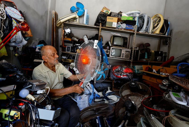 A Palestinian, Mustafa Abdou, repairs fan in his shop amid a heatwave at Shati refugee camp in Gaza City. Reuters 