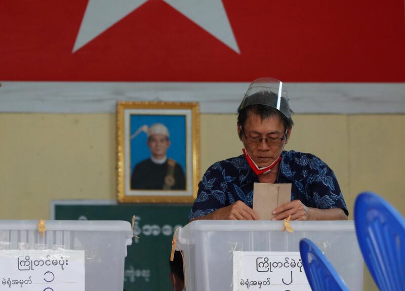 An elderly man casts his ballot during early voting at a polling station in Yangon. EPA