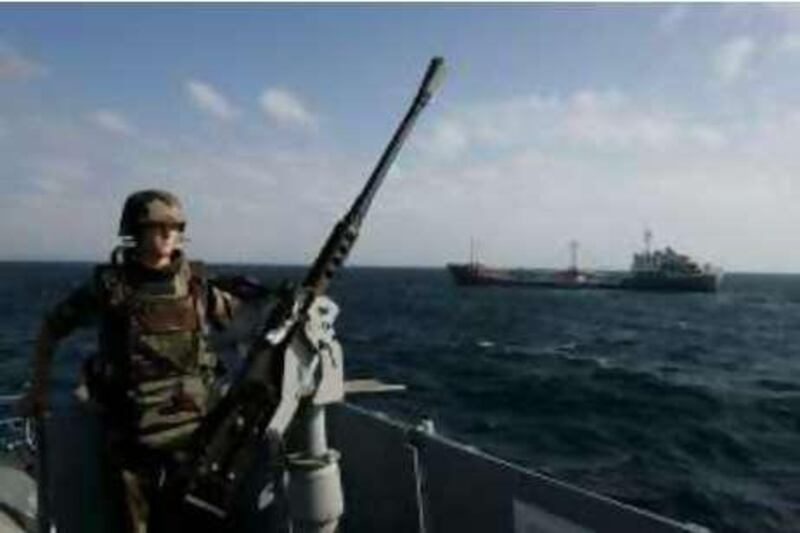 ** FILE ** A French soldier on board the French warship Premier Maitre L"Her, with the cargo ship Victoria in the background in this Saturday, Dec. 15, 2007 file photo taken off the Somali coast. Since last month, the merchant ships that deliver 80\% of the World Food Program aid have been accompanied by French warships, and host a team of elite French commandos that camp on their deck ,machine-guns at the ready. It was announced Friday April 4, 2008 that pirates have seized control of a French luxury yacht carrying 30 crew members in the Gulf of Aden off Somalia's coast, according to the French government and the ship's owne. (AP Photo/Karel Prinsloo, File) ... 17-12-2007 ... Photo by: KAREL PRINSLOO/AP/PA Photos.URN:5831951