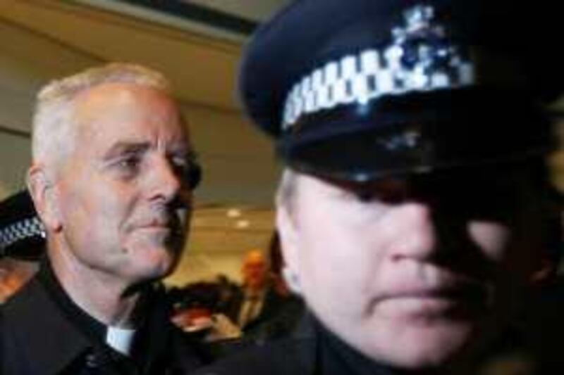 British-born Roman Catholic Bishop Richard Williamson (L) is escorted by police on his arrival at Heathrow Airport in London February 25, 2009. A Roman Catholic bishop who caused an international uproar by denying the scale of the Holocaust arrived back in his native Britain on Wednesday after the Argentine government ordered him out.   REUTERS/Luke MacGregor (BRITAIN) *** Local Caption ***  LON103_BRITAIN-BISH_0225_11.JPG