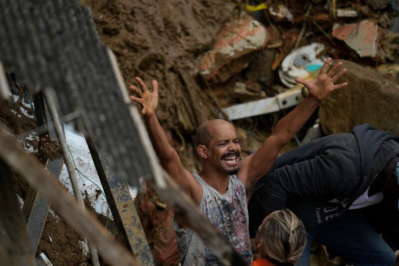 A resident yells during the search for survivors. AP